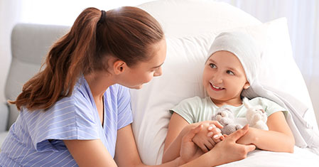 Woman visiting her daughter who is undergoing course of chemotherapy in clinic. Childhood cancer awareness concept